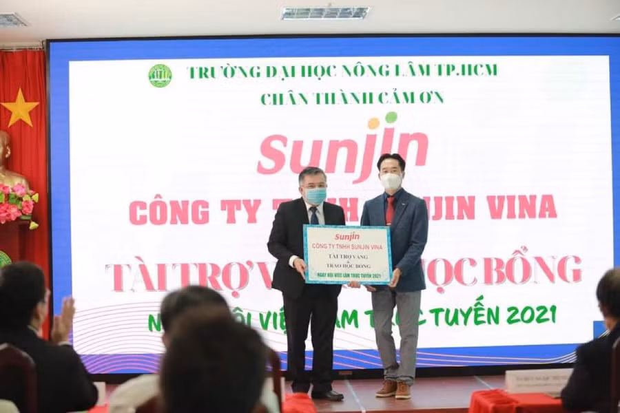 PGS.TS Huỳnh Thanh Hùng(trái) nhận biểu trưng tài trợ Vàng từ đơn vị đồng hành