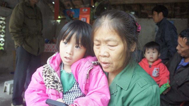 Bà Nguyễn Thị Tam bế cháu Lê Nguyễn Thanh Ngân - con gái của nạn nhân Nguyễn Thị Thu.