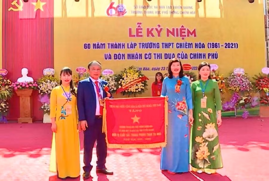 Thừa uỷ quyền của Thủ tướng Chính phủ, Phó Chủ tịch HĐND tỉnh Phạm Thị Minh Xuân trao tặng Cờ Thi đua cho Trường THPT Chiêm Hóa.