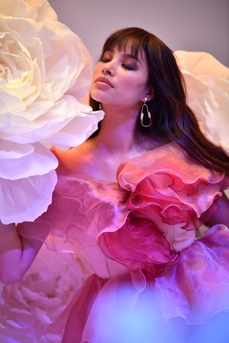 Hoa hậu Hoàn vũ Việt Nam 2015 mặc bộ đầm nhún bèo tương đồng với các bông hoa đạo cụ. Cô trang điểm nhấn vào mắt, đánh khối đậm.