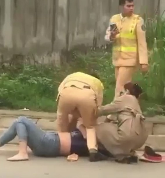 Lực lượng CSGT khống chế người phụ nữ. (Ảnh: Cắt từ clip).