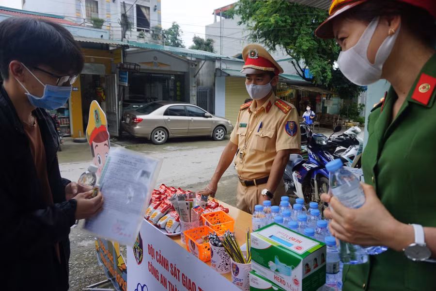 Đoàn viên thanh niên Công an tỉnh Điện Biên phát đồ ăn miễn phí cho thí sinh tại điểm trường THPT Phan Đình Giót, TP Điện Biên Phủ