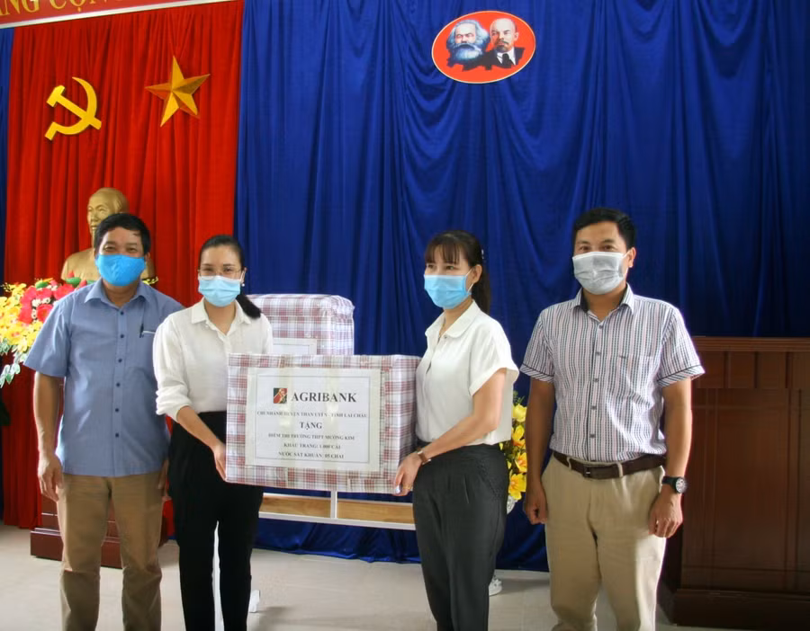 Đại diện Agribank chi nhánh Than Uyên trao quà cho 3 điểm thi.