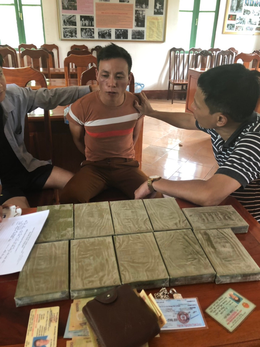 Đối tượng Phàn Vần Páo (ngồi giữa) cùng tang vật