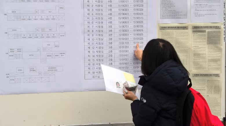 Một nữ sinh kiểm tra số phòng thi trước kỳ thi đại học CSAT năm 2017. Truoc ky thi kho nhat trong nam, Han Quoc xon xao ve gian lan thi cu hinh anh 1