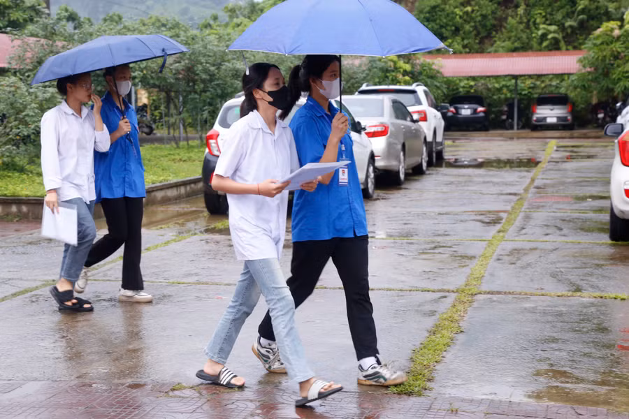 Những ngày diễn ra Kỳ thi tốt nghiệp THPT, các tỉnh Tây Bắc thường có mưa. Đội ngũ tình nguyện viên đã hỗ trợ đưa, đón thí sinh đi ra vào điểm thi an toàn. Trong ảnh: Hỗ trợ thí sinh tại huyện Bát Xát (Lào Cai).