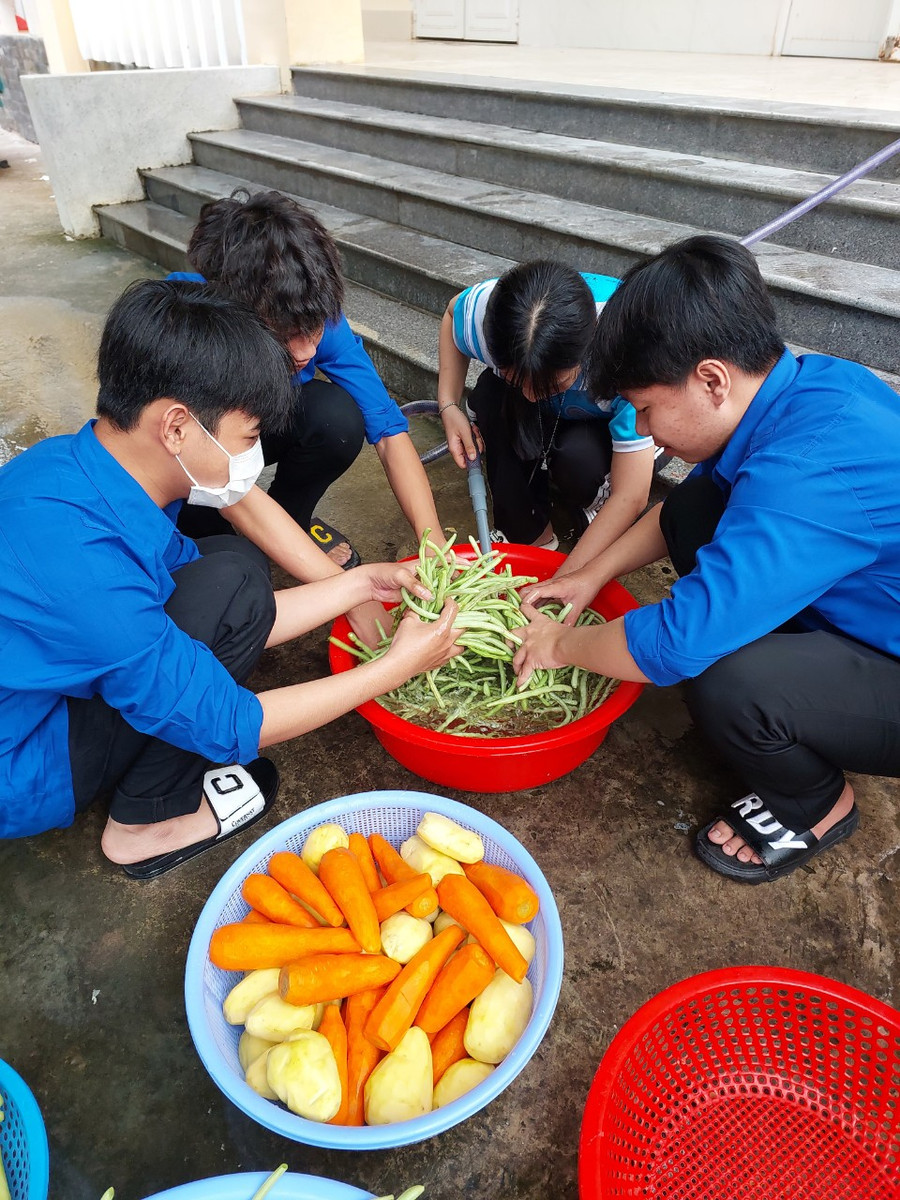 Các học sinh, thầy cô của trường tham gia nấu ăn cho thí sinh.