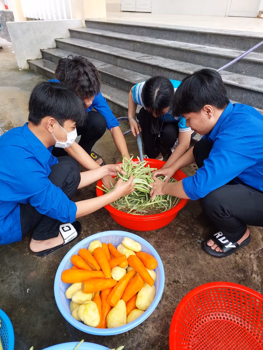 Các học sinh, thầy cô của trường tham gia nấu ăn cho thí sinh.