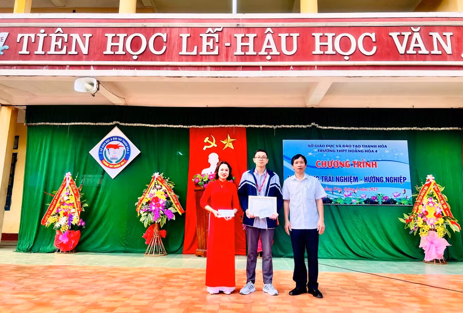 Thầy Nguyễn Hữu Kỳ - Hiệu trưởng nhà trường trao thưởng em Lê Trung Hiếu và giáo viên hướng dẫn Lê Hải Lý.
