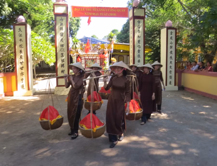 Người dân làng Lương Quán phường Thủy Biều sau khi dâng cúng tại đình làng Lương Quán được gánh bộ thanh trà xuống sông Hương vào Đại Nội