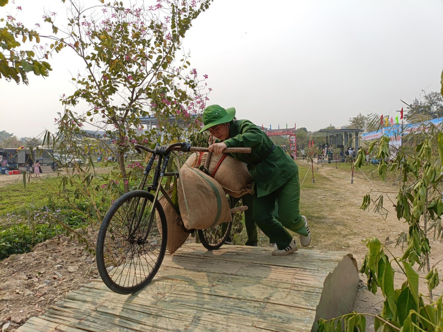 Các VĐV đẩy xe đạp thồ qua nhiều chướng ngại vật.