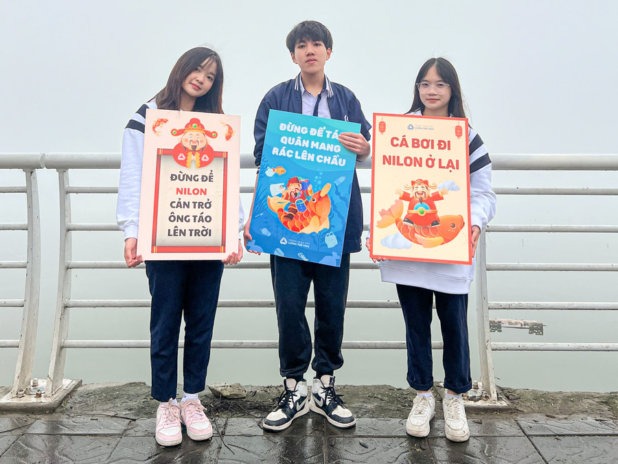 Những biển hiệu mang thông điệp về bảo vệ môi trường được các em mang theo để tuyên truyền tới người dân khi đi thả cá.