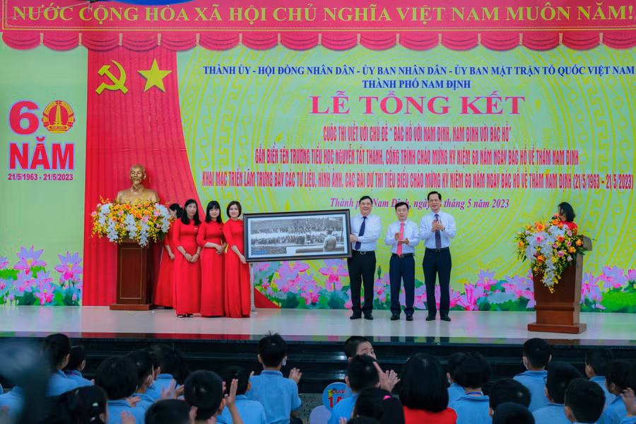 Đại diện BGH Trường Tiểu học Nguyễn Tất Thành đón nhận món quà từ lãnh đạo tỉnh Nam Định nhân dịp lễ gắn biển công trình chào mừng 60 năm Bác Hồ về thăm Nam Định.