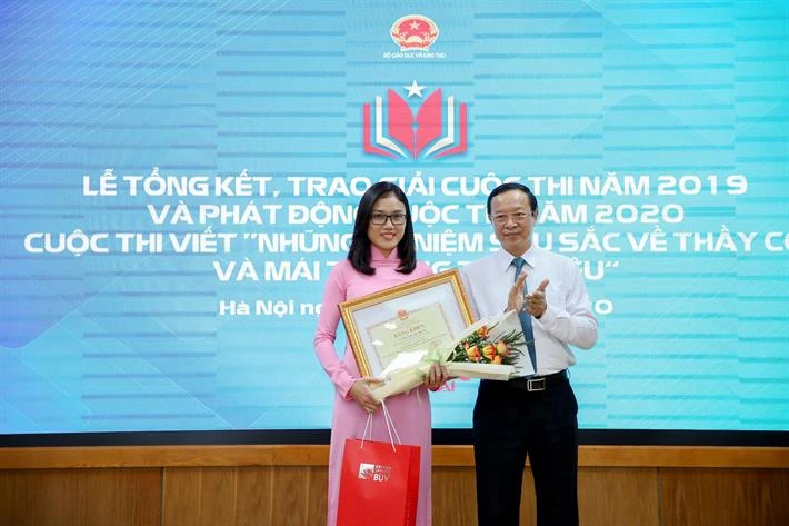 Thứ trưởng Phạm Ngọc Thưởng trao giải Nhất cuộc thi viết “Những kỷ niệm sâu sắc về thầy cô và mái trường mến yêu năm 2019" cho cô giáo Lường Thị Thu Trang. (Ảnh: gdtd.vn)