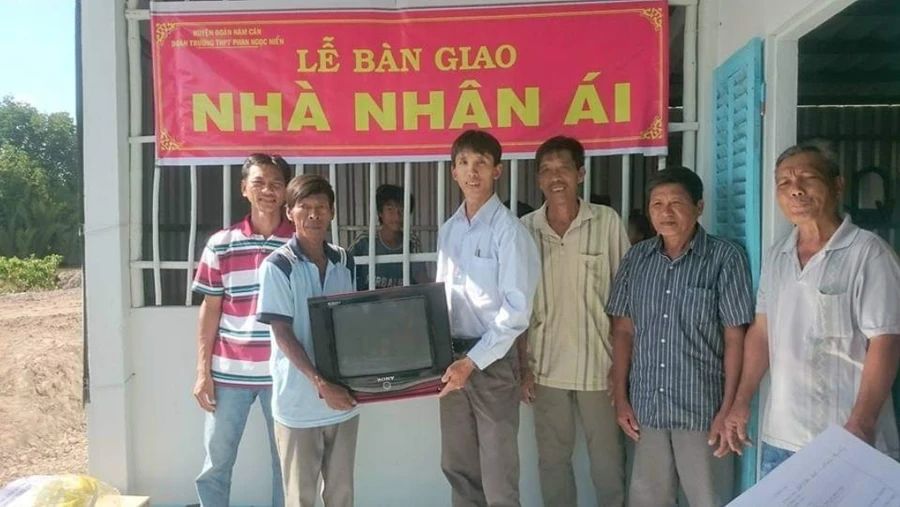 Thầy Nguyễn Ngọc Hân (áo trắng trao quà) trong một chuyến từ thiện. Ảnh: NVCC