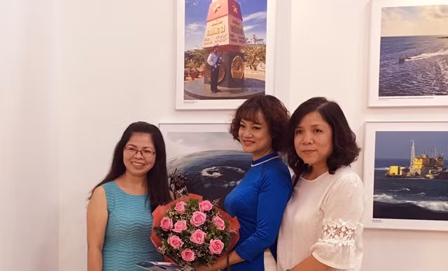 Nhà báo Nguyễn Mỹ Trà (đứng giữa) cùng bạn bè	đồng nghiệp trong ngày triển lãm ảnh "Trường Sa trong ta"