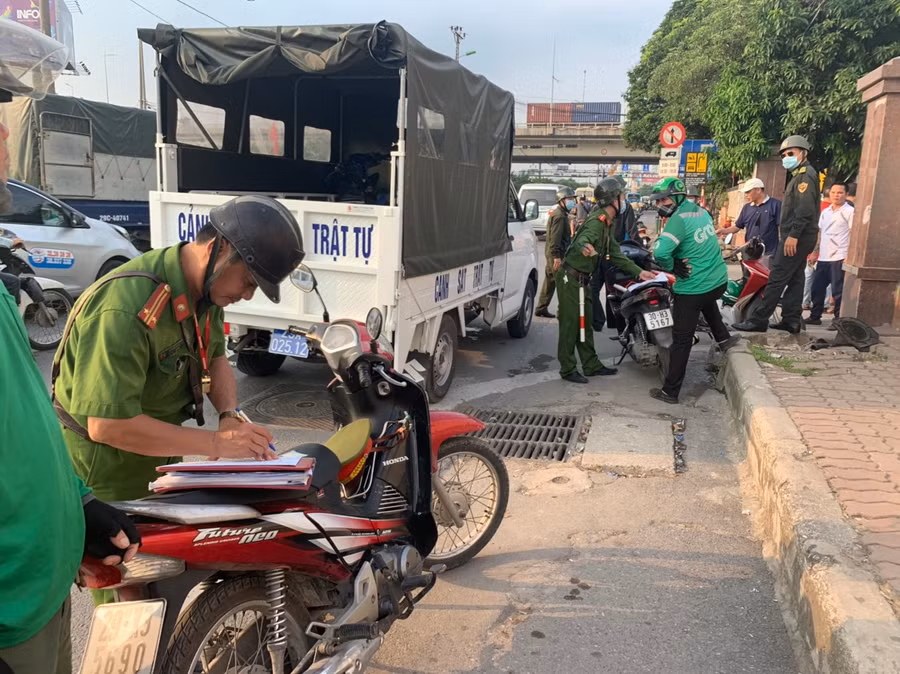 Công an phường Hoàng Liệt xử lý các tài xế xe ôm công nghệ vi phạm giao thông khu vực quanh bến xe Nước Ngầm.