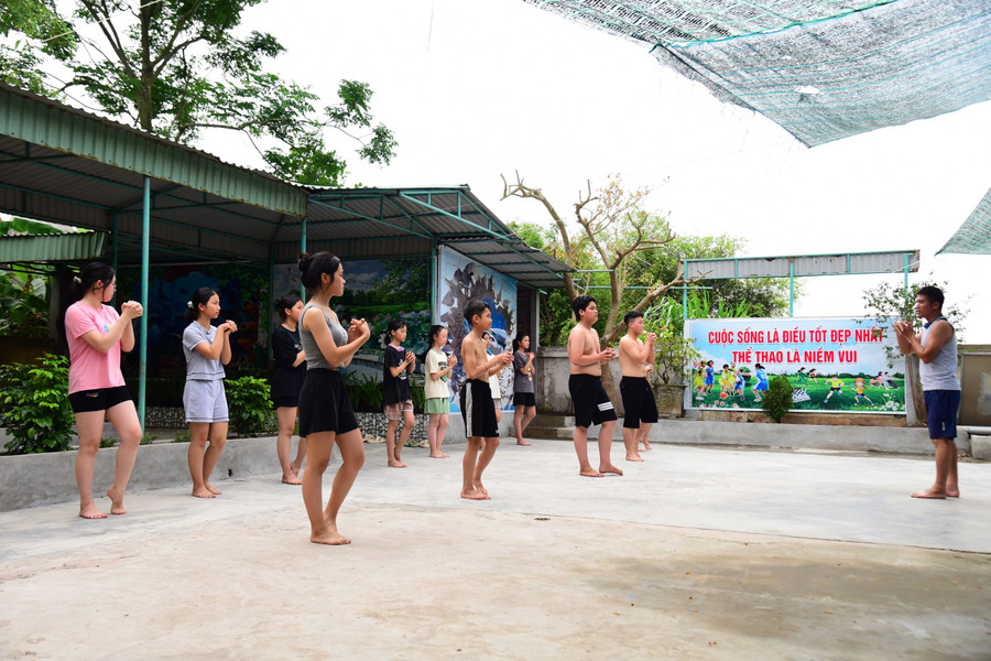 Thầy trò cùng tập các động tác khởi động trước khi vào học bơi.