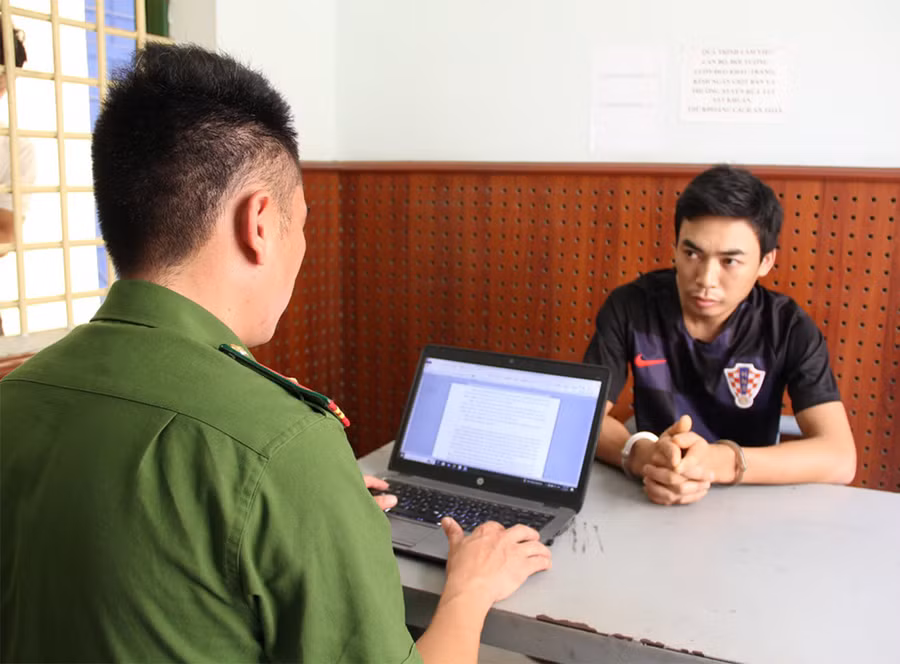 Công an lấy lời khai của Vi Xuân Thành. Ảnh: CANA.