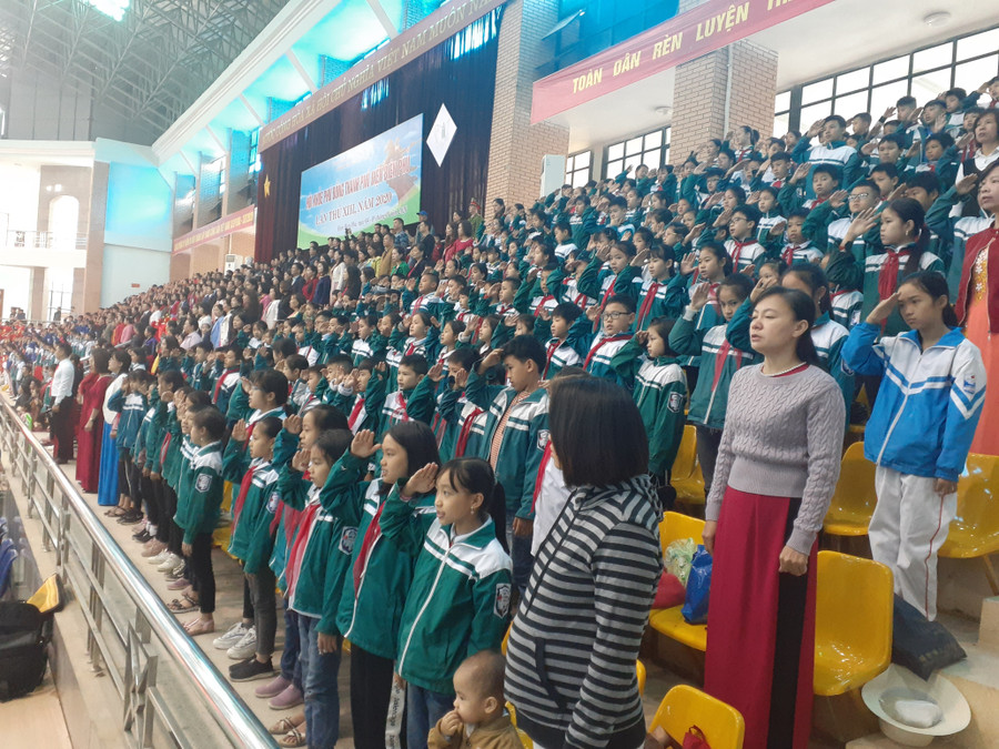 Các đại biểu cùng đông đảo học sinh các trường thực hiện nghi thức chào cờ