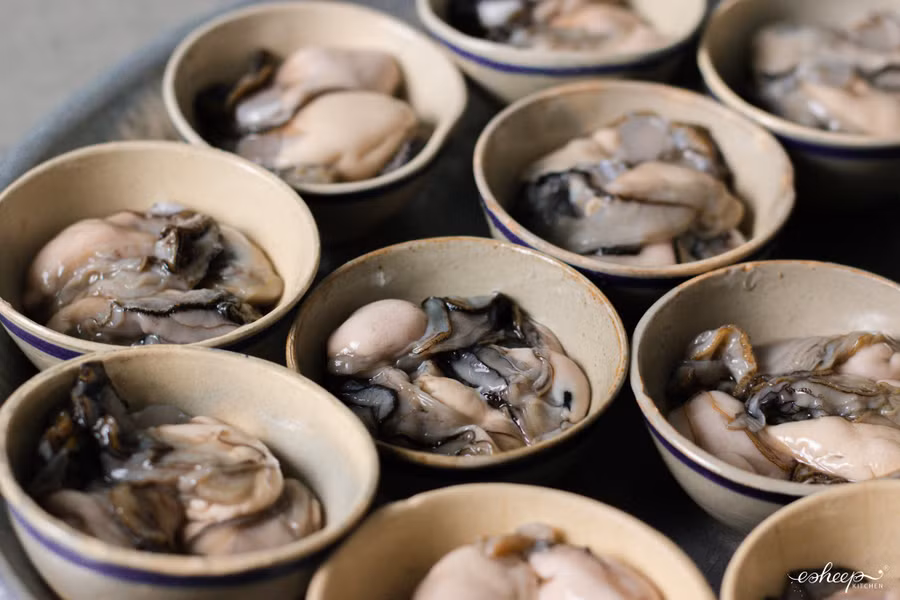 Hàu chỉ cần tráng sơ với nước lọc, xếp hàu vào từng chén gốm hoặc khuôn giấy bạc. Không cần tẩm ướp gì vì hàu mặn sẵn.