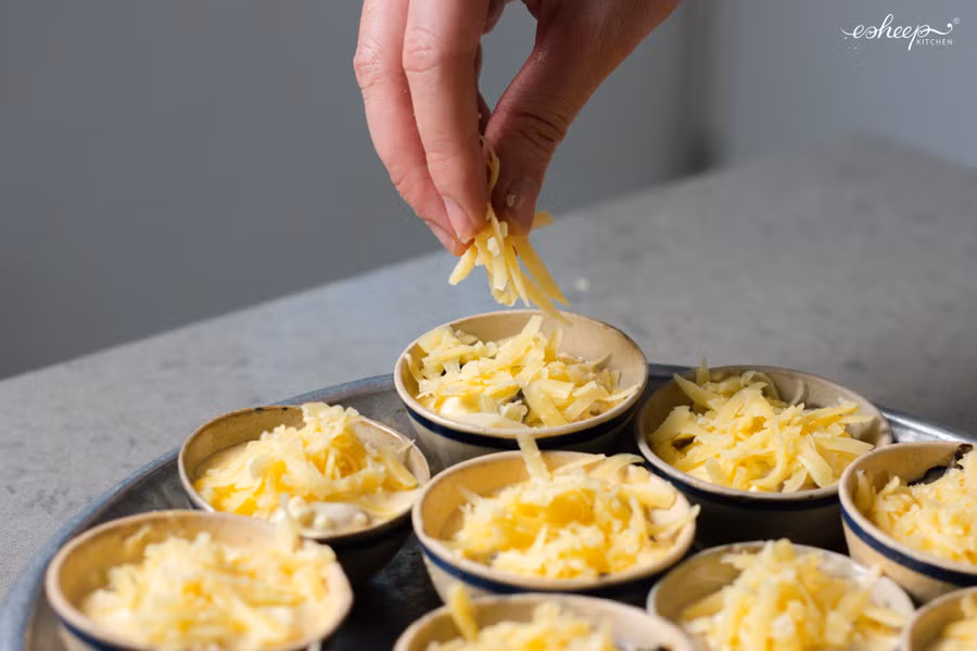 Rắc thêm phô mai bào sợi phủ hết mặt chén.