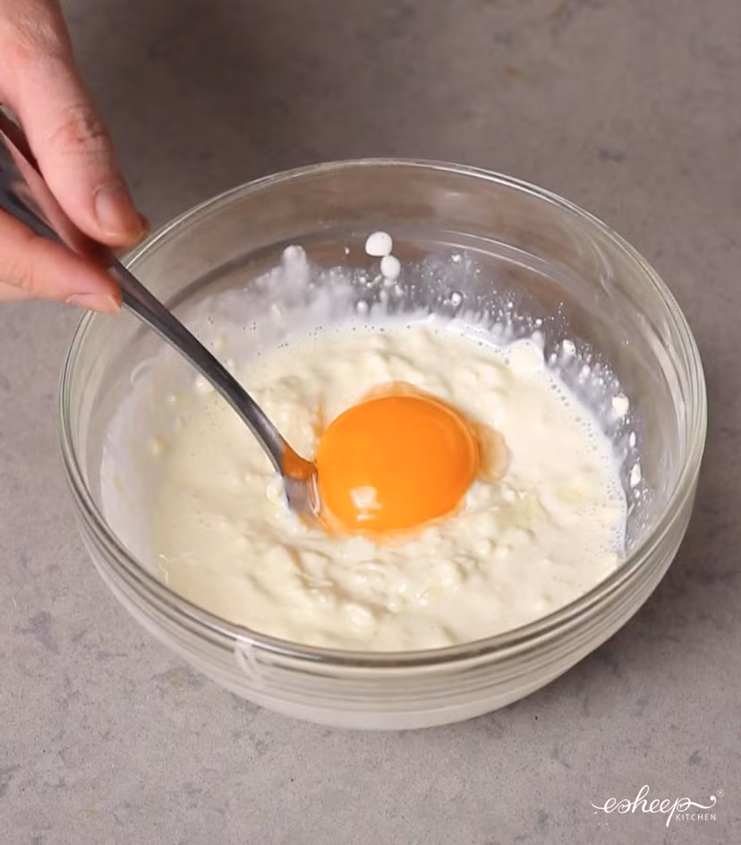 Thêm 1 lòng đỏ trứng gà đánh cho quyện sẽ được hỗn hợp sốt phô mai thơm ngậy, có màu vàng kem tuyệt đẹp.