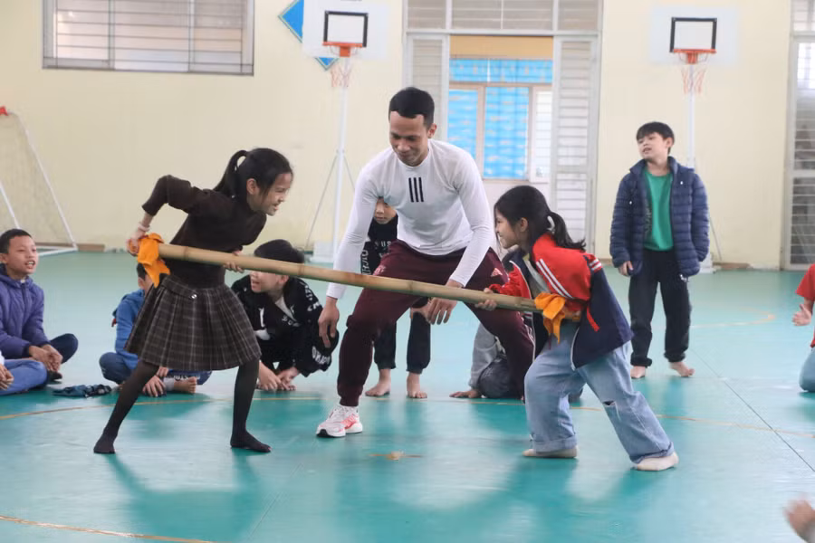 Thầy giáo hướng dẫn các em học sinh chơi trò Đẩy gậy.