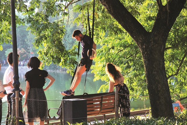 Một du khách nước ngoài đang biểu diễn những động tác thể dục dụng cụ đẹp mắt ngay gần cầu Thê Húc