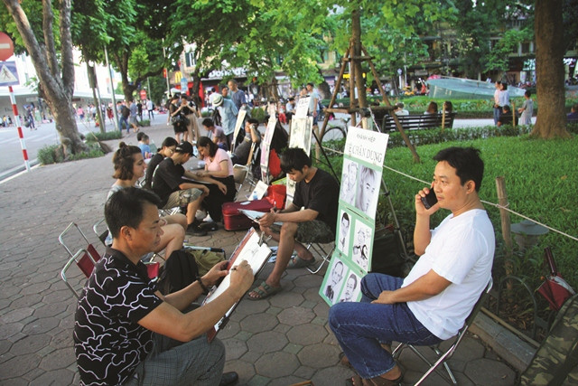 Nhiều du khách đều tranh thủ nhờ các họa sỹ vẽ một bức ký họa làm kỷ niệm chuyến thăm hồ Gươm