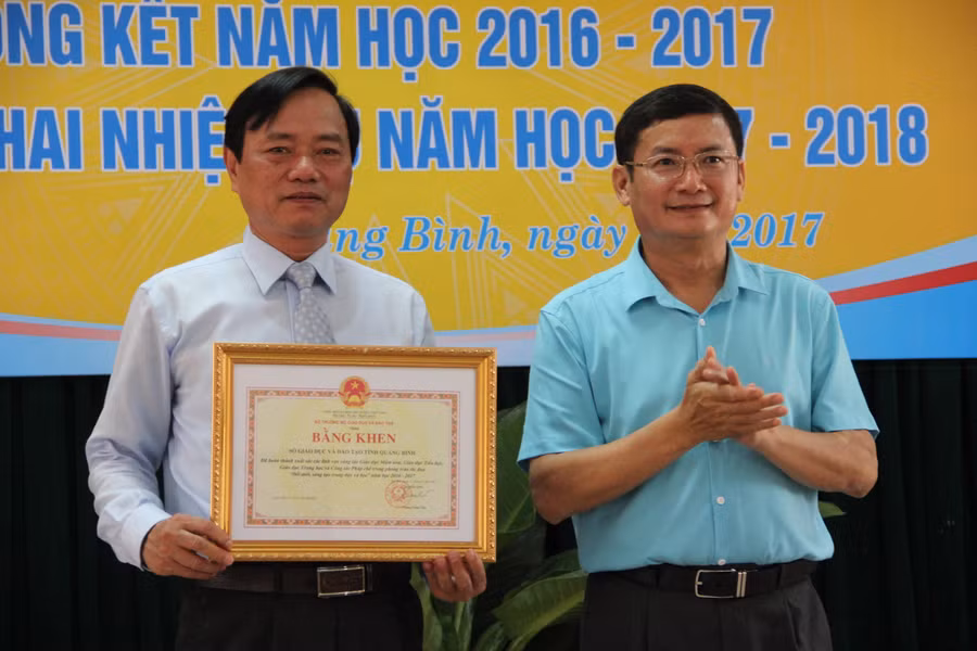 Ông Trần Tiến Dũng, phó Chủ tịch UBND tỉnh Quảng Bình trao tặng bằng khen cho Sở GD&ĐT tỉnh Quảng Bình vì những thành tích đạt được trong năm học vừa qua.