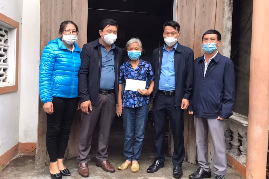 Chị Huyền (áo xanh) cùng lãnh đạo địa phương tặng quà cho người cao tuổi.