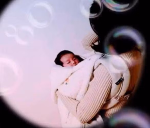 Bé ngủ ngon lành trong vòng tay bố mẹ.