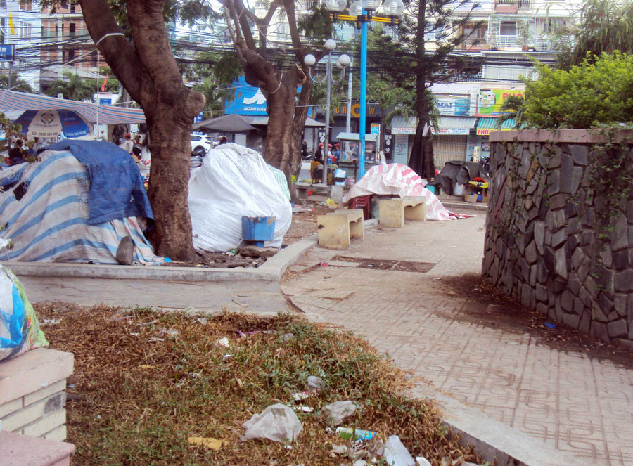 Cảnh công viên hoang hóa thành bãi tập kết bàn ghế, hàng hóa của các cửa hàng giải khát ven đường