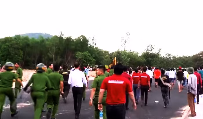 Hàng loạt nhân viên mặc áo đỏ in dòng chữ "Tập đoàn Alibaba" hò hét kích động cản trở việc cưỡng chế.