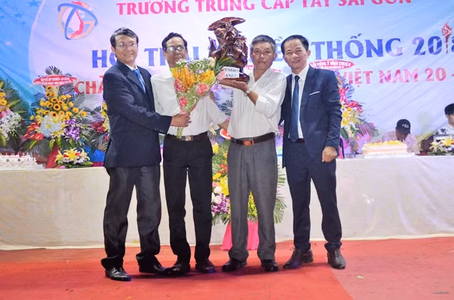 Một học viên lớn tuổi nhận quà kỉ niệm của Ban giám hiệu nhà trường tại lễ kỉ niệm ngày Nhà giáo Việt Nam 20/11