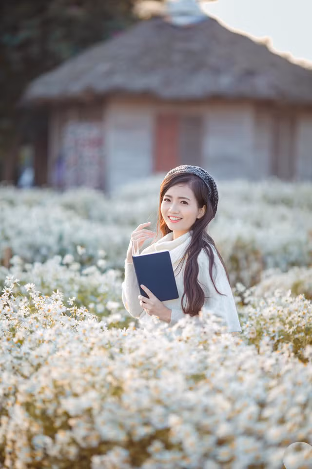  Vẻ đẹp dịu dàng của cô giáo trẻ hòa với sắc trắng tinh khôi của loài hoa mùa đông. 