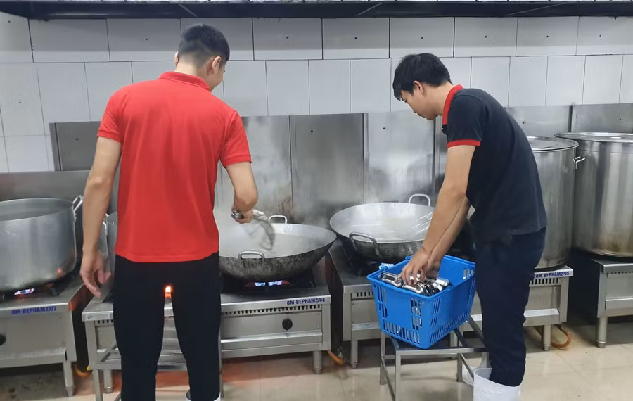 Nhân viên bếp ăn Trường Tiểu học Đông Thái (Tây Hồ, Hà Nội) tiệt trùng dụng cụ, chuẩn bị bữa ăn bán trú an toàn. (Ảnh: Nhà trường)