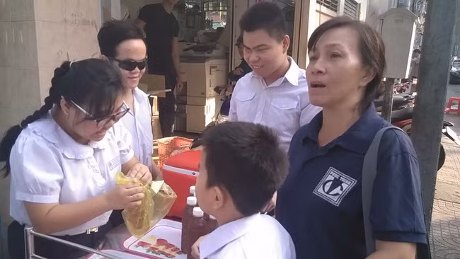 Thanh Mai cẩn thẩn thận bỏ chai nước sâm vào túi để đưa cho khách