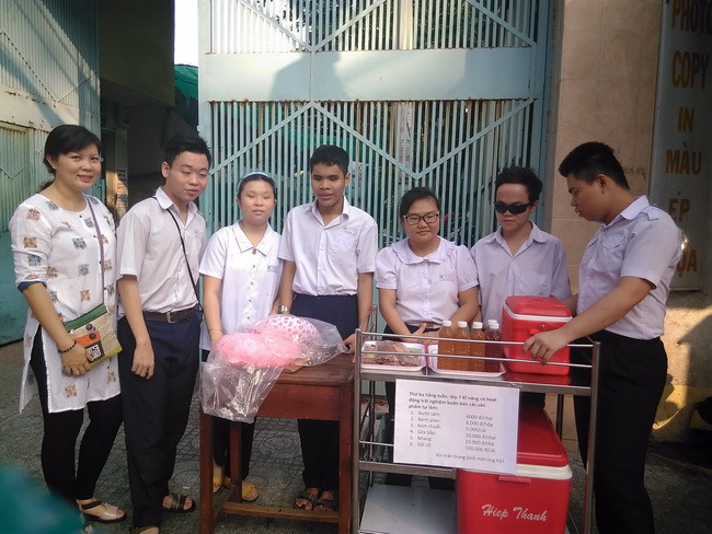 Cô Kim Phượng cùng các học trò bên kệ hàng đặt ngay cổng Trường