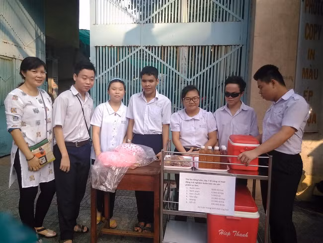 Cô Kim Phượng cùng các học trò bên kệ hàng đặt ngay cổng Trường