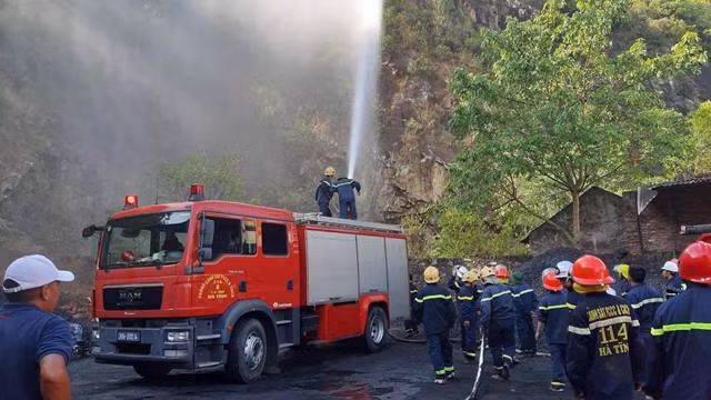 Lực lượng chức năng tiếp tục phun nước ngăn ngọn lửa cháy trở lại khu vực nhà dân tại tổ 1, thị trấn Xuân An.