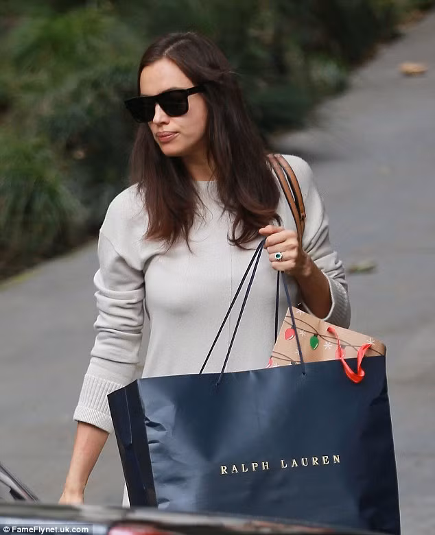  Irina Shayk lọt vào tầm ngắm của giới săn tin khi rời khỏi khách sạn Beverly Hills, ngày 21/12. Người đẹp Nga diện váy rộng thùng thình và đi bốt cao cổ. Cô lấy chiếc túi che lên phần bụng để tránh mọi ánh nhìn tò mò. 