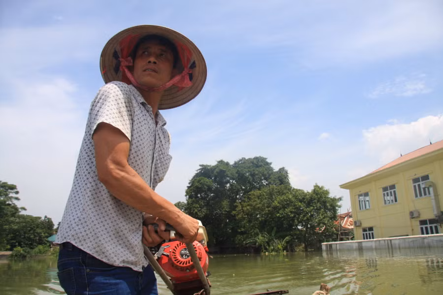 Ông Trịnh Văn Định, thôn Tiến Tiên, xã Tân Tiến dùng xuồng máy của gia đình để trở mọi người ra vào thôn Ông Trịnh Văn Định, thôn Tiến Tiên, xã Tân Tiến dùng xuồng máy của gia đình để trở mọi người ra vào thôn