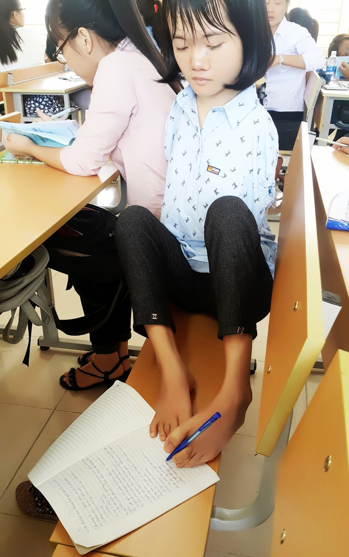 Không tay, phải viết bằng chân nhưng Thắm luôn nỗ lực vươn lên. (Ảnh: NVCC).