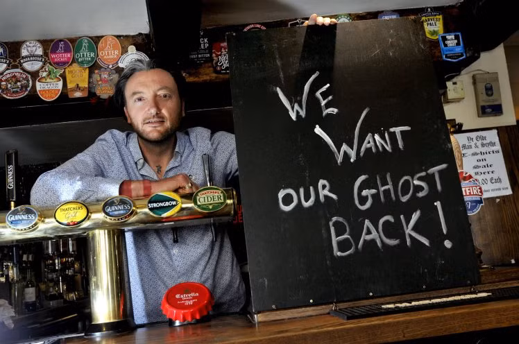 Chủ quán bar Olde Man and Scythe bên tấm biển Hãy trả ma lại cho chúng tôi