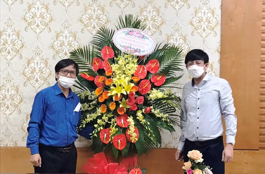 Ông Đỗ Văn Cường (phải) - Chánh Văn phòng Sở GD&amp;ĐT Thanh Hóa đón nhận lẵng hoa chúc mừng của Báo GD&amp;TĐ – VP Miền Trung - Tây Nguyên.