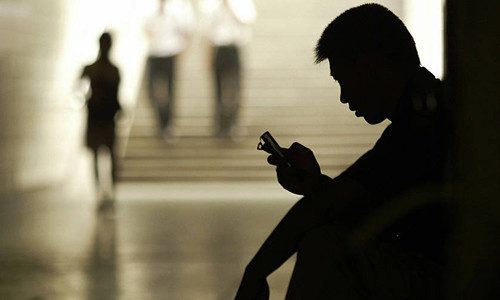 Một người đàn ông dùng điện thoại di động nhắn tin trong một đường hầm đi bộ ở Bắc Kinh, Trung Quốc. Ảnh: AFP.