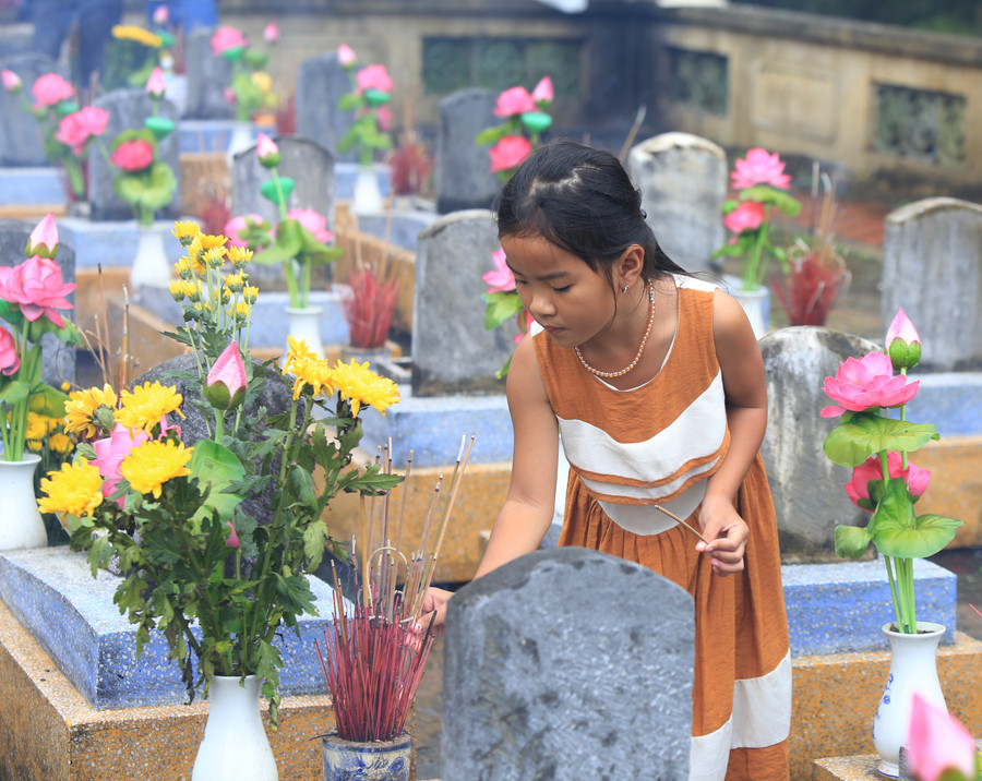 Cháu bé dâng hương cho các liệt sĩ tại nghĩa trang Trường Sơn