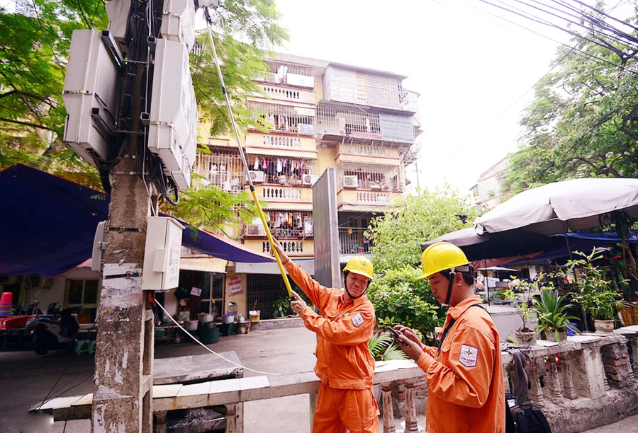 Công nhân ngành điện sử dụng công nghệ trong việc ghi số điện tiêu thụ dân dụng